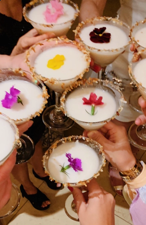 Tropical coconut cocktails with toasted coconut rims and edible flowers served by a Maui private chef